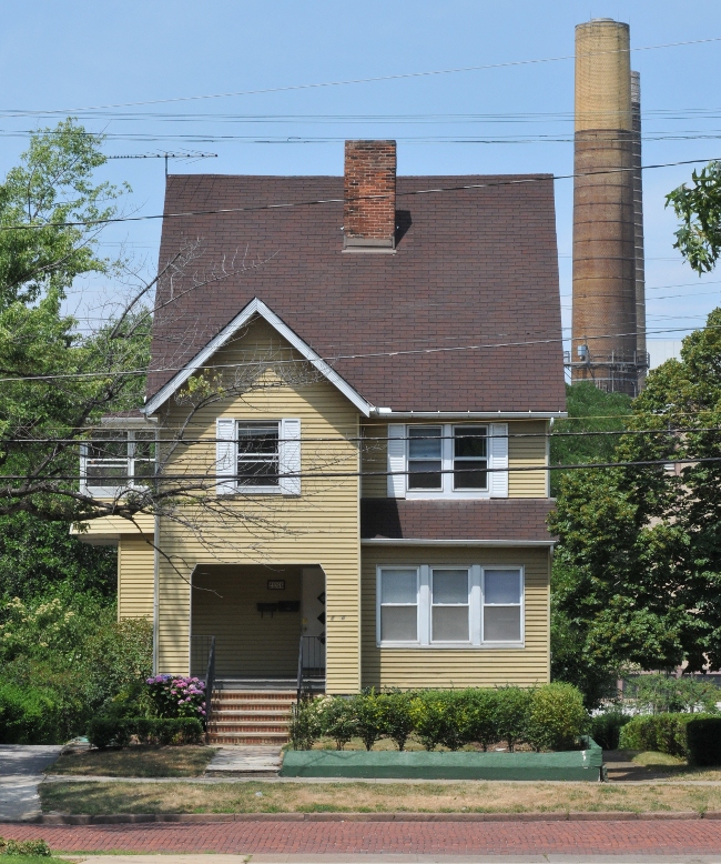 House in Little Italy Ohio, owned by Case, overshadowed by stacks from coal plant