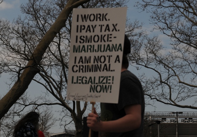 Medical Marijuana advocate at Cleveland Rally carrying "I work, I vote, I smoke Marijuana" sign